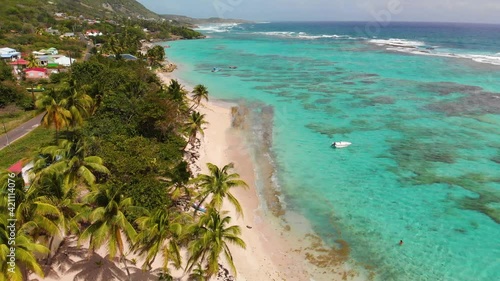 Aerial view of a paradise beach with turquoise water in the Caribbean, little boat, travelling by drone. La Désirade, Guadeloupe