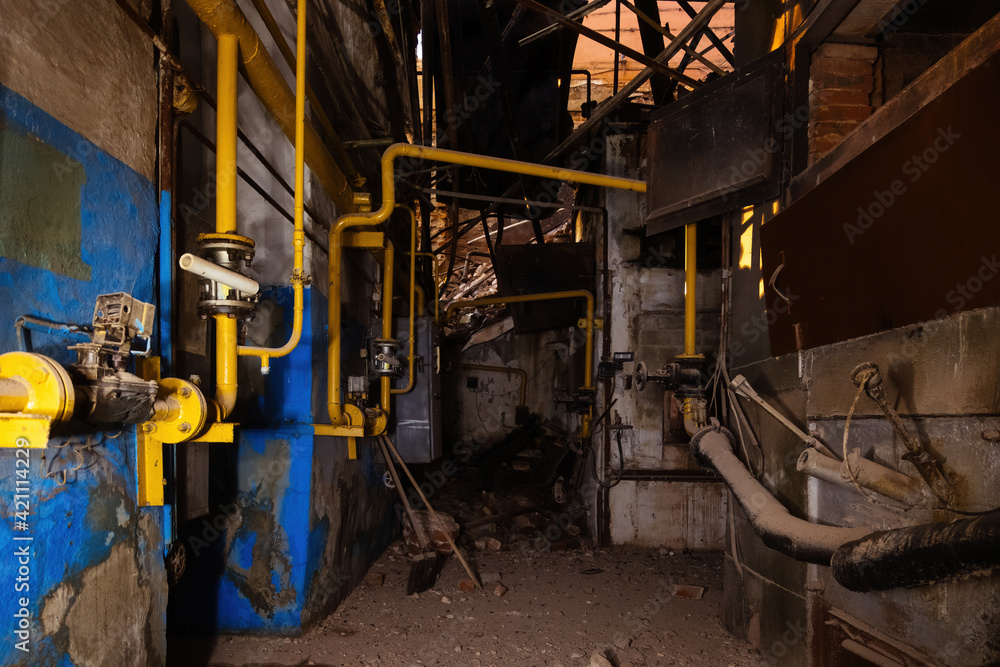 Inside old collapsed industrial building. Old rusty pipeline