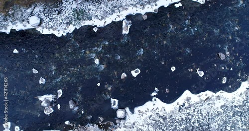 Thawed Ice Water Flows In The River With Coniferous Forest On The Sides