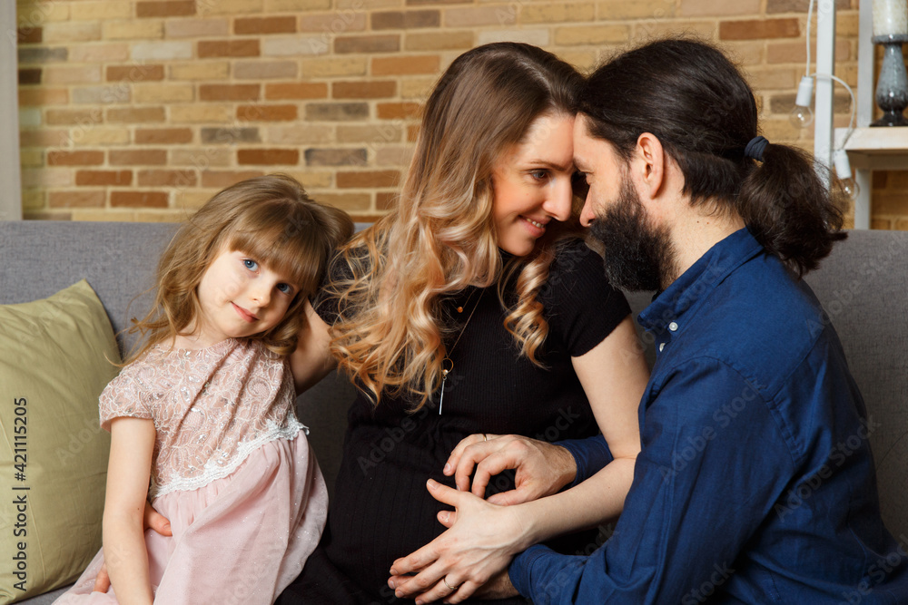 Happy young father, mother and daughter sit on wicker sofa at home. Happy young father, mother and daughter sit on wicker sofa at home.
