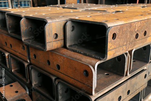 Thick metal products, cut on plasma and bent on a bending machine, lie in the central building of a heavy industry plant.