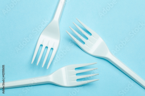 Plastic forks on a blue background. Plastic waste and pollution concept