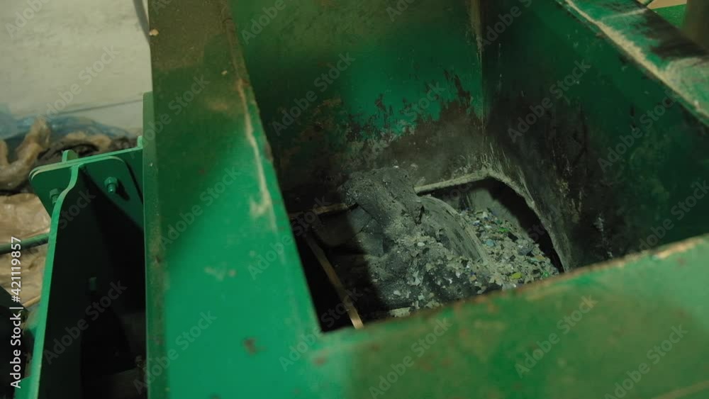 A worker in a plastic recycling factory begins the process of creating a trash can. Pours a special mixture into the oven, forms the mass on the press, takes out the finished product. A worker in a plastic recycling factory begins the process of creating a trash can. Pours a special mixture into the oven, forms the mass on the press, takes out the finished product.