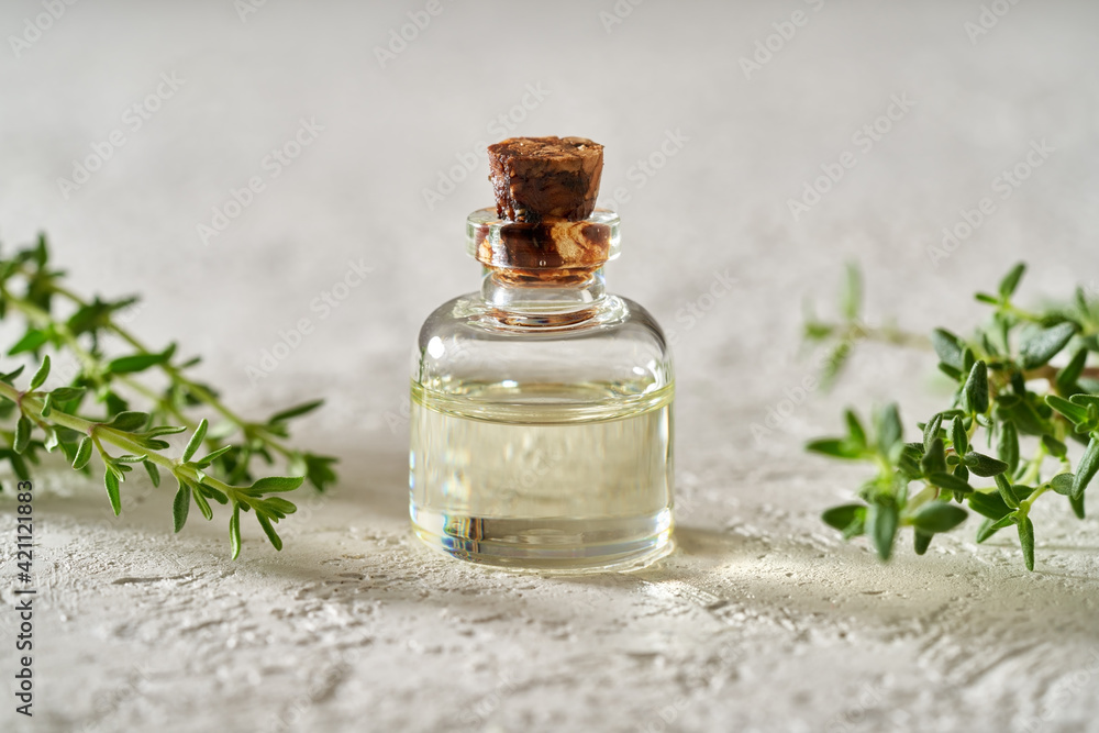 A bottle of essential oil with fresh thyme twigs A bottle of essential oil with fresh thyme twigs