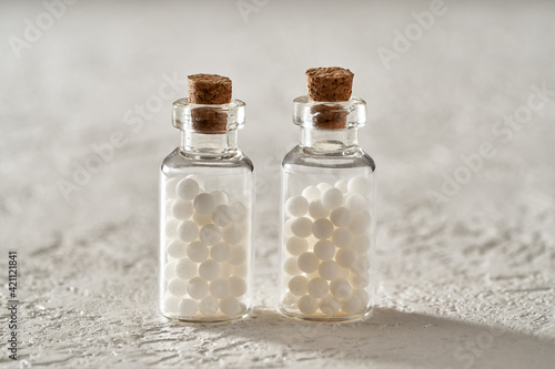 Two bottles of homeopathic pills on a white background