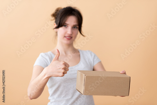 A European woman advertising a box in the foreground is gesturing with her hand.