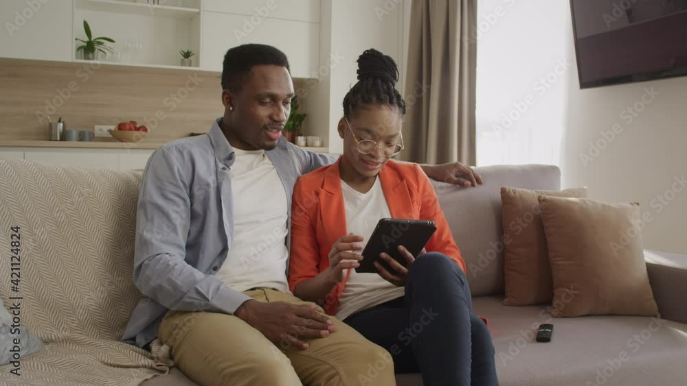 Young african american family is surfing the web on the tablet computer while shopping online Young african american family is surfing the web on the tablet computer while shopping online