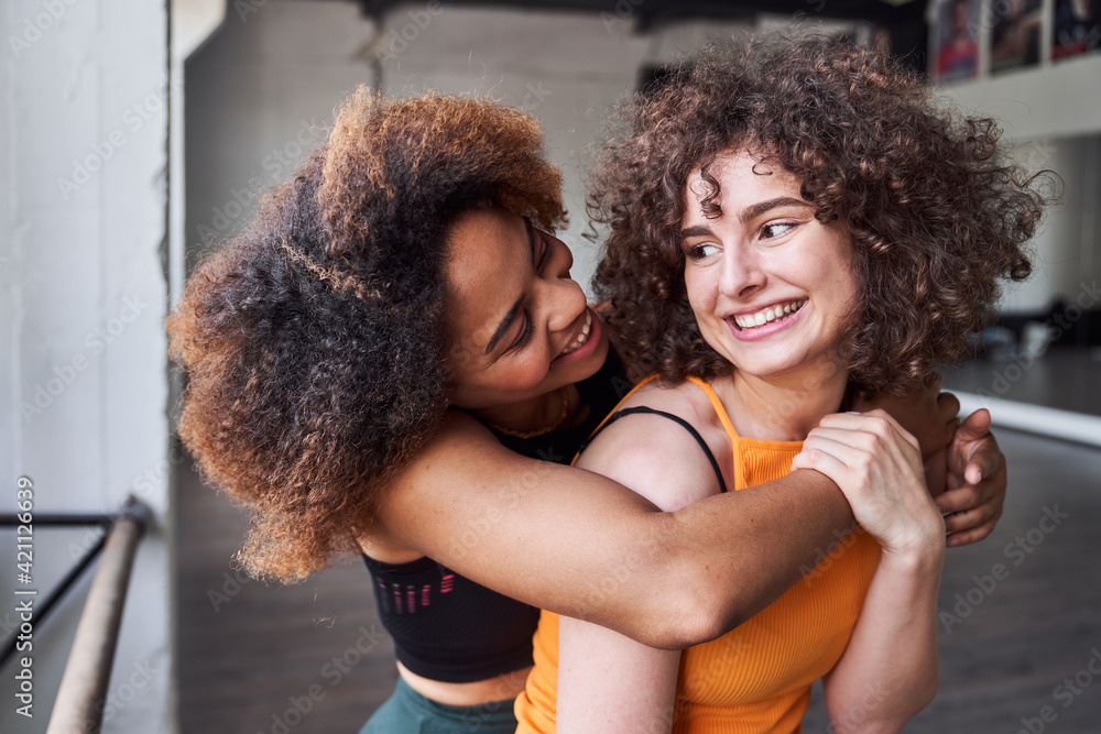 Smiling two women looking each other in studio Smiling two women looking each other in studio