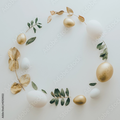 Flat Lay of Golden Easter Eggs ring circle on white background. Easter background or easter concept. Still life, pastel toned