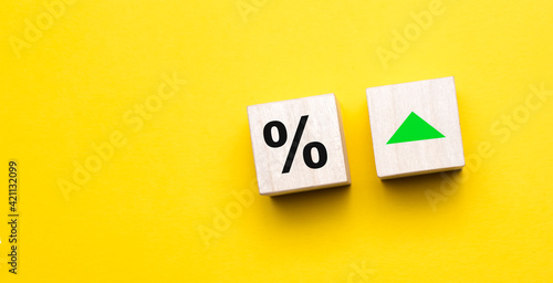 Percent sign on wooden cubes against yellow background with copy space. Concept of sale and discount.