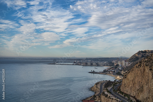 beautiful sunrise on the beach with rocks and clouds, located in Alicante, Spain.