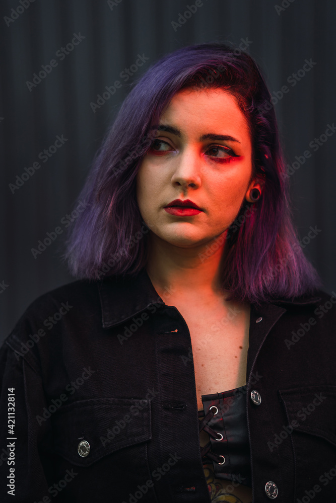 Portrait of a young woman with purple hair posing with red light Portrait of a young woman with purple hair posing with red light