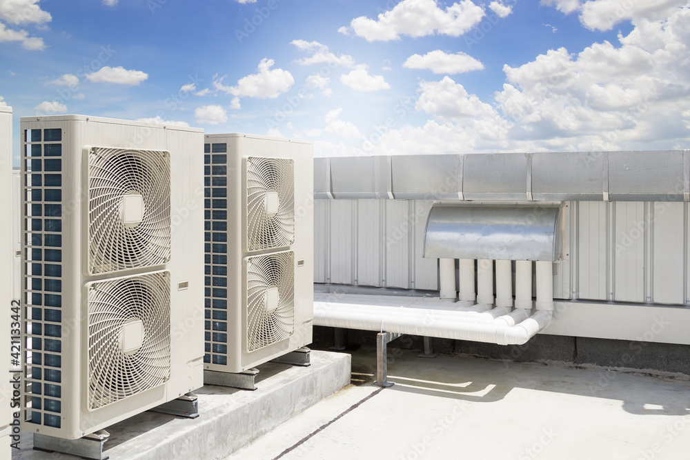 Condenser unit or compressor on roof of industrial plant building with