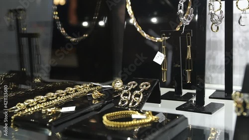 Beautiful jewelry on store shelves shimmer in different colors in rays of light. Closeup.