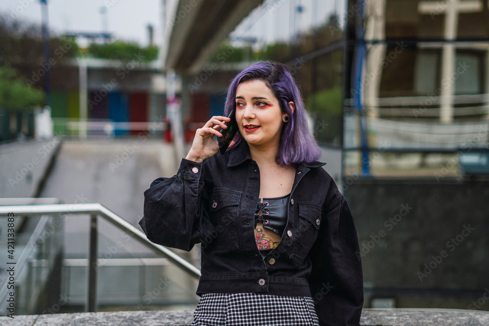 Young woman with purple hair talking on cell phone
