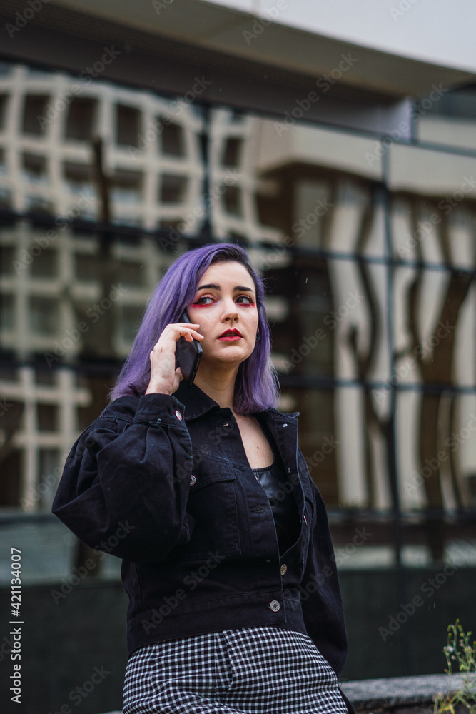 Young woman with purple hair talking on cell phone