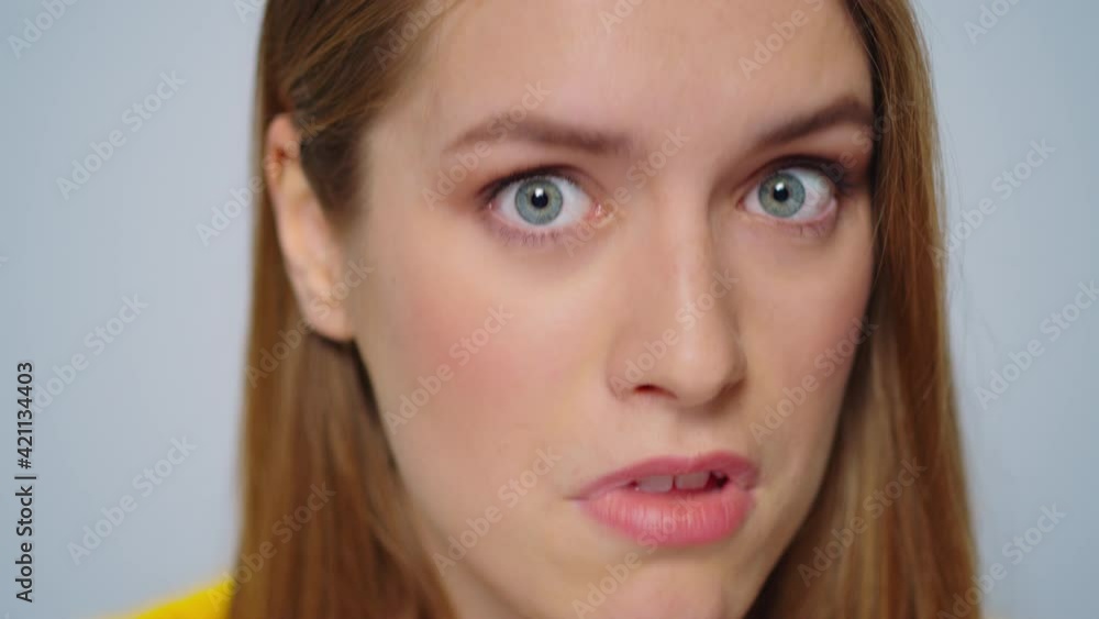 Closeup angry woman waving head on camera in studio. Sarcastic woman face Closeup angry woman waving head on camera in studio. Sarcastic woman face