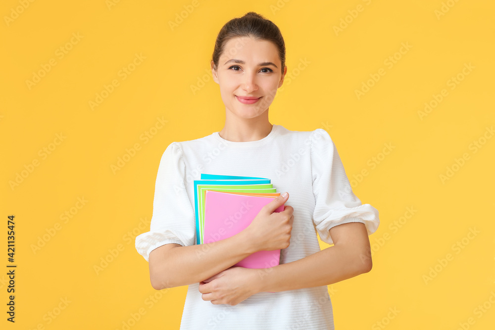 Young woman with notebooks on color background Young woman with notebooks on color background
