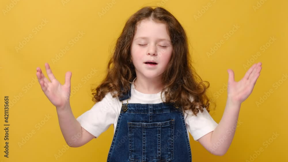 Calm happy little preschooler girl stretching relaxing, positive smiling small child with eyes closed feel peaceful breathing fresh air, good pleasant smell, isolated on yellow studio background Calm happy little preschooler girl stretching relaxing, positive smiling small child with eyes closed feel peaceful breathing fresh air, good pleasant smell, isolated on yellow studio background