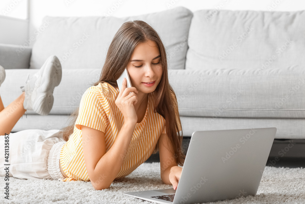 Young woman with laptop talking by mobile phone at home Young woman with laptop talking by mobile phone at home