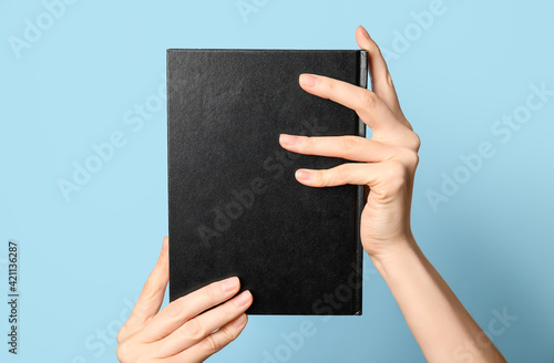 Woman holding book on color...