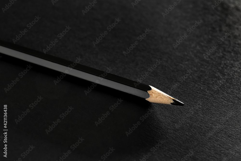 Black pencil on dark background, closeup Black pencil on dark background, closeup