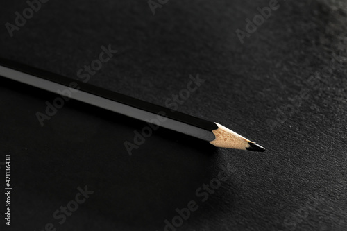 Black pencil on dark background, closeup