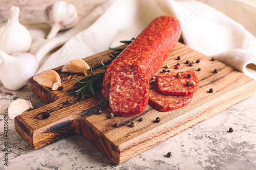 Tasty salami with spices on grunge background