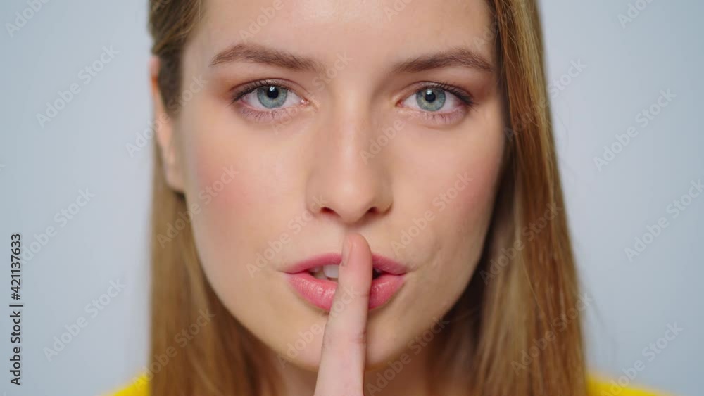 Closeup sensual beautiful lady flirting on camera in studio. Girl keeping secret Closeup sensual beautiful lady flirting on camera in studio. Girl keeping secret