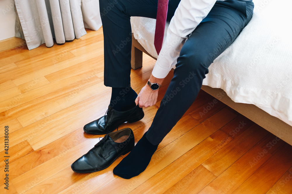 Young businessman putting on shoes