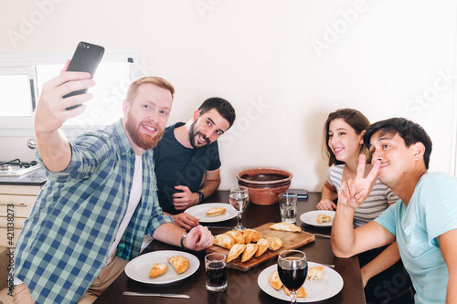 group of friends making a selfie while having lunch