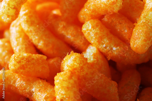 Close-up of a pile of cheesies cheese snack food.