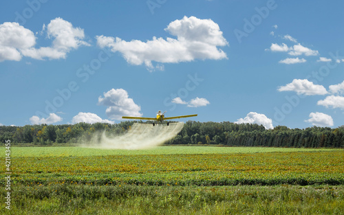 Canvastavla crop duster spraying a farm field pesticide.