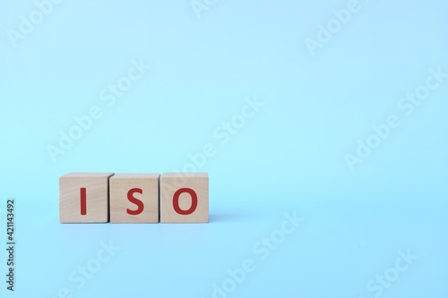 ISO acronym or International Organization for Standardization on wooden blocks in blue background.