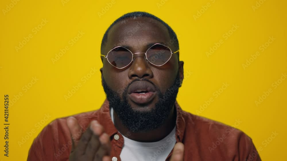 Portrait of handsome afro man sending air kiss to camera on yellow background. Portrait of handsome afro man sending air kiss to camera on yellow background.