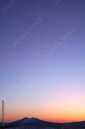 : 山の稜線と美しいグラデーションの夜明けの空。