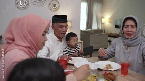 muslim asian family and grandparents having break fasting on ramadan. iftar dinner break