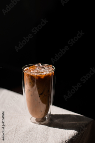 Close-up glass of iced coffee with milk on the table