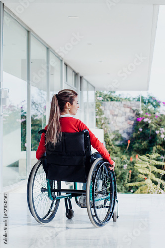 Young latin woman in wheelchair at workplace