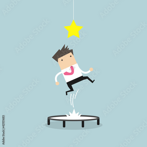 Businessman trying to catch the star by jumping on trampoline.