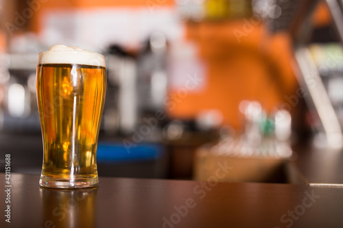 Photos Image of light Beer in a traditional pint glass on table in bar