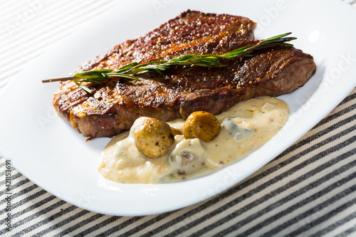 Image of beef entrecote with mushroom sauce on the plate indoors.