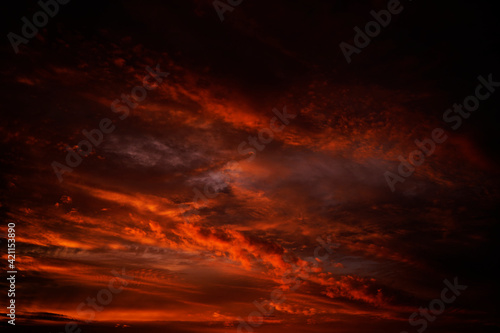Abstract dark red background. Dramatic fiery bloody sky. Fantastic golden sunset background with copy space for design. Halloween, evil, armageddon, apocalypse concept. Web banner.