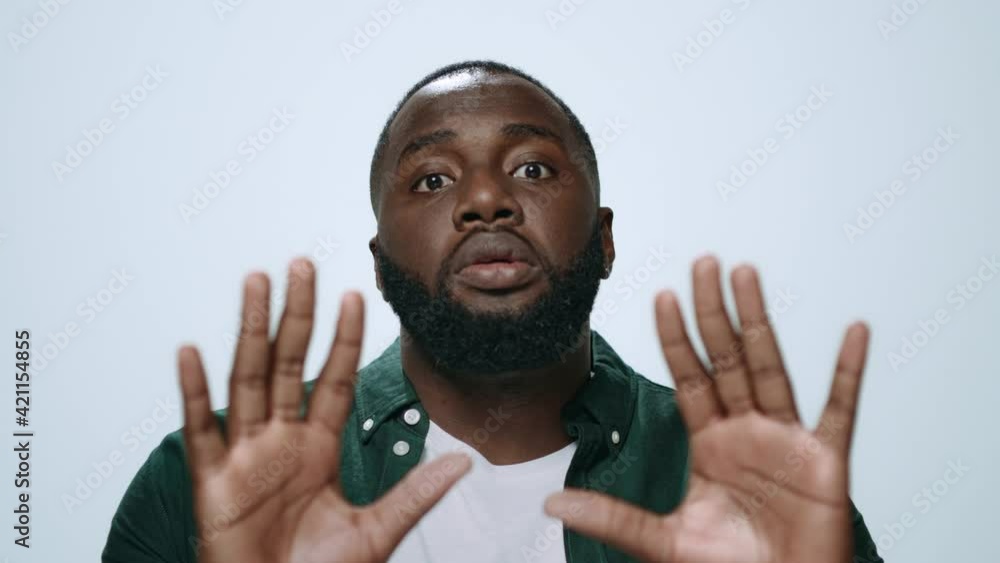 Portrait upset african man showing please gesture on light background. Portrait upset african man showing please gesture on light background.