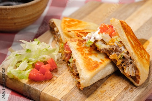 A close up photo of a homemade crunch wrap taco on a cutting board.