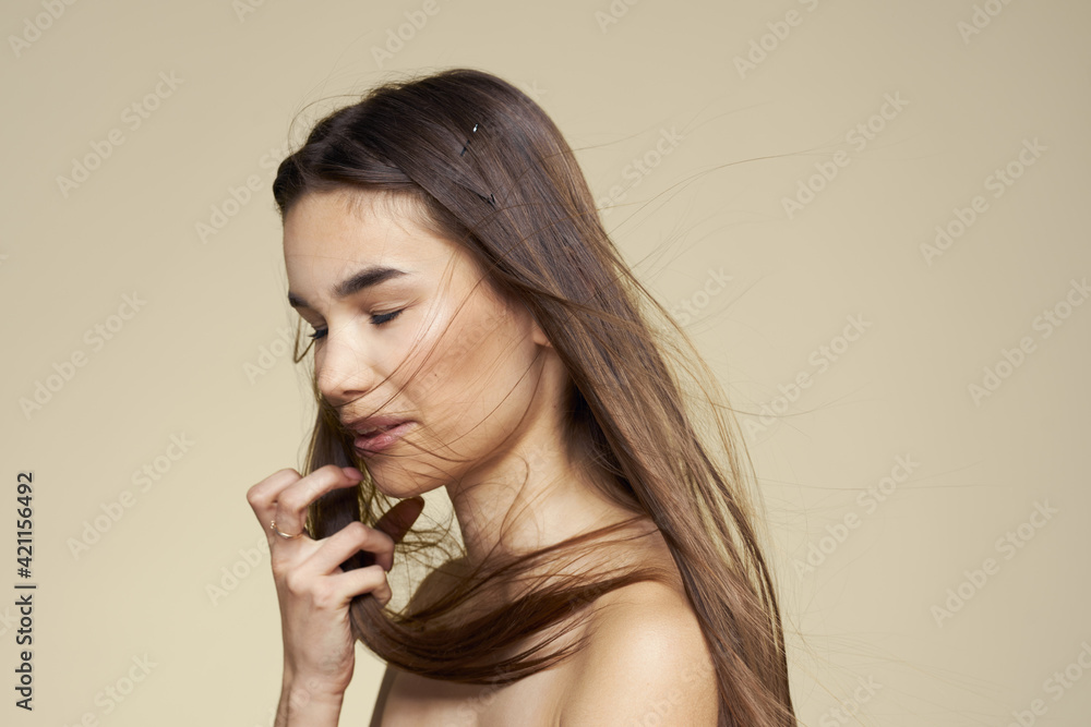 Fototapeta premium Pretty woman naked shoulders long hair body care beige background