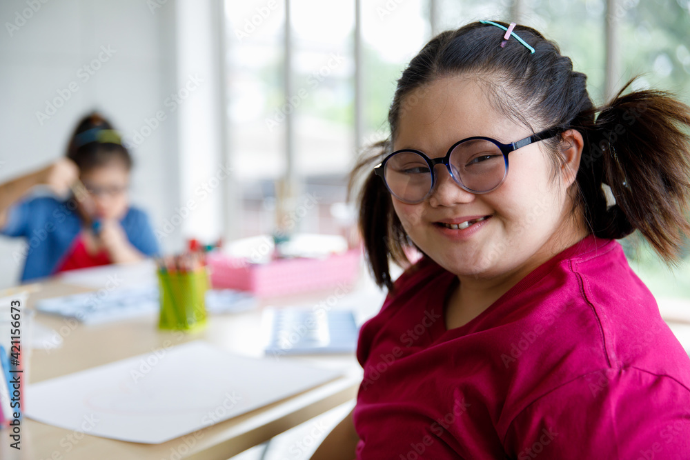 Happy girl with Down syndrome gesturing V sign