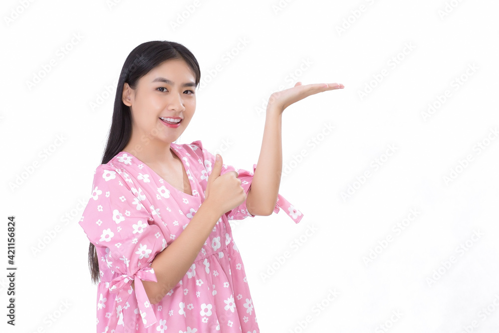 Asian beautiful woman with black long hair in white shirt shows thumb up and present something on white background. Asian beautiful woman with black long hair in white shirt shows thumb up and present something on white background.