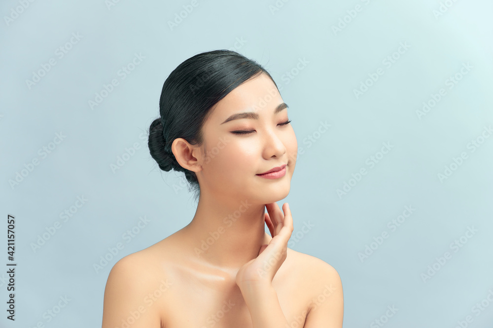 asian young beautiful woman smiling and touching her neck. isolated on light background. asian young beautiful woman smiling and touching her neck. isolated on light background.