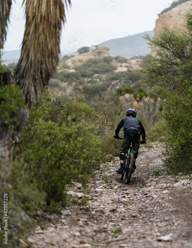 unrecognizable cyclist on rocky road